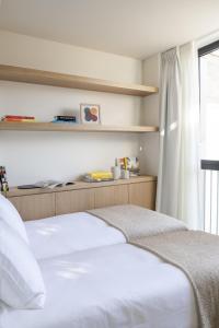 1 Schlafzimmer mit 2 Betten und einem Fenster in der Unterkunft The Onsider - Penthouse 3 Bedroom Apartment - Paseo de Gracia in Barcelona