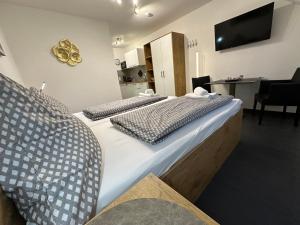 2 Betten in einem Zimmer mit einem TV an der Wand in der Unterkunft Gocher Berghof Ferienwohnungen Langanke in Goch