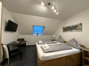 Habitación con 2 camas, escritorio y ventana. en Gocher Berghof Ferienwohnungen Langanke, en Goch