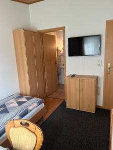 a bedroom with a bed and a flat screen tv at Pension Lydia in Leipzig