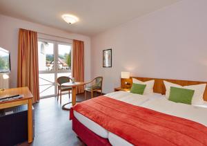 a hotel room with a bed and a balcony at Zum Turm - Apartments und Gästezimmer in Oberammergau