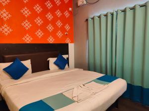 a bedroom with a bed with blue and green curtains at Udupi Comforts in Udupi