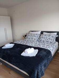 Apartman TESA في Sanski most: غرفة نوم عليها سرير وفوط