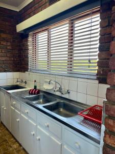 uma cozinha com um lavatório e uma parede de tijolos em Magdamol holiday home em Witsand