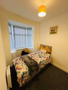 um quarto com uma cama e uma janela em 4 Bed 4 Bath 6 Guest Lovely home em Stoke on Trent