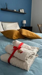 a pile of towels on a bed with a red ribbon at Appartamento Vittoria in Vittoria