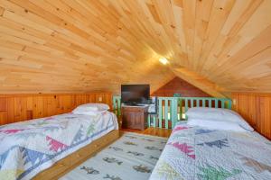 sypialnia z dwoma łóżkami i telewizorem w kabinie w obiekcie Warm and Cozy Clayton Cabin Near St Lawrence River! w mieście Clayton