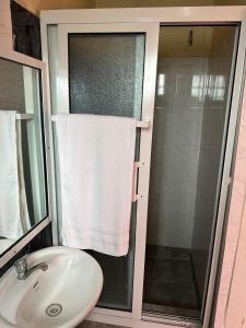 baño con lavabo y ducha con toalla en STONE CASTLE HOTEL, en Freetown