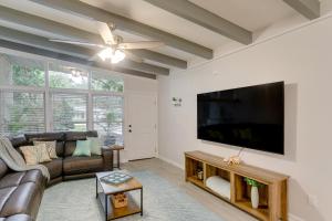a living room with a couch and a flat screen tv at Bright Jekyll Island Home with Deck Less Than 1 Mi to Beach in Jekyll Island