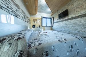 a bedroom with a large bed and a brick wall at Norman Tower Spa in Casalbore