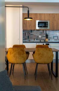 cocina con mesa con 2 sillas y microondas en Apartamentos 1 Abril, en Málaga