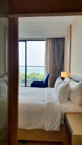um quarto de hotel com uma cama grande e uma janela em Seaview Cam Ranh Beach Resort Nha Trang Near The Airport Best Location em Cam Ranh