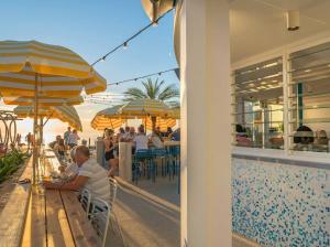 a boy sitting on a bench next to a restaurant at 'The Grange' Coastal Charm near Henley Beach in Adelaide