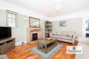 ein Wohnzimmer mit einem Sofa und einem Kamin in der Unterkunft BOURNECOAST:LARGE HOME MINUTES FROM BEACH- HB6228 in Bournemouth