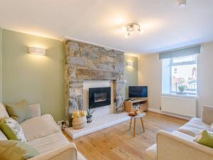 a living room with a stone fireplace and a tv at 2 bed in Llanrwst 83295 in Llanrwst