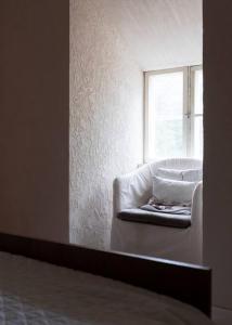 Una silla blanca en una habitación con ventana en Tunnelmallinen kaksio hirsitalossa 