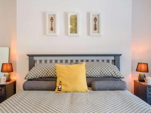 a bedroom with a bed with a yellow pillow at 2 bed in Llanrwst 83295 in Llanrwst