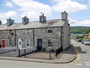 un antiguo edificio de piedra al lado de una calle en 2 bed in Llanrwst 83295 en Llanrwst