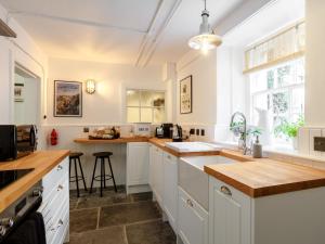 una cocina con armarios blancos y encimeras de madera en 2 Bed in Beauly 78962, en Beauly