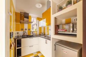 a kitchen with yellow walls and white cabinets at Piazza Navona Penthouse in Rome