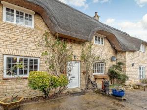 a thatch roofed house with a white door at 4 bed in Rutland Water 86556 in Empingham
