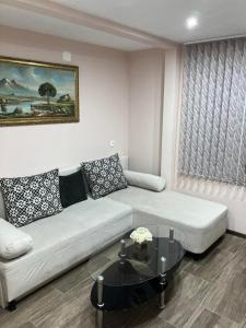 uma sala de estar com um sofá e uma mesa de centro em Къща за гости Теяна em Tryavna