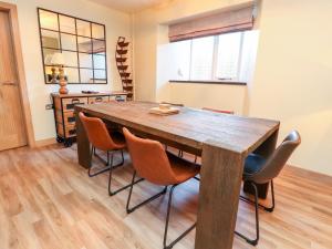 a dining room with a wooden table and chairs at Eldroth in Skipton