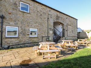 a group of picnic tables in front of a brick building at Malham in Skipton