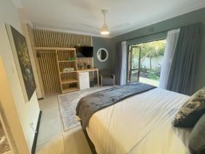 1 dormitorio con cama y ventana grande en Wilderness on Sea, en Wilderness