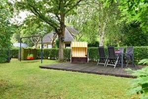 - une terrasse en bois avec des chaises et un grill dans la cour dans l'établissement An der Löwenhöhle, à Wyk auf Föhr