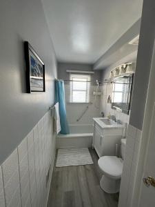 Spotless 2 Bedroom Suite in Winnipeg في وينيبيغ: حمام مع مرحاض وحوض استحمام ومغسلة