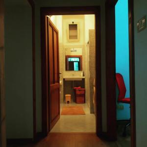 an open door to a hallway with a red chair at Casa Cavallotti in Acquasparta