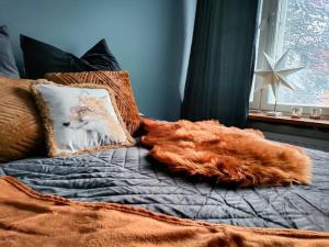 uma cama com um cobertor laranja e almofadas em Arctic Foxy Studio em Rovaniemi