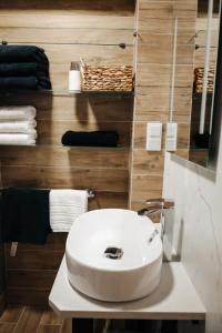 baño con lavabo blanco y toallas en Villa Agnes Jacuzzi & Sauna en Jasienica
