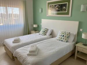 アルヴォルにあるApartamento Vila Marachiqueのベッドルーム1室(ベッド2台、タオル付)