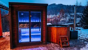 a sauna with a glass door and a wooden stool at Villa Agnes Jacuzzi & Sauna in Jasienica