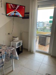 a bedroom with a tv on the wall next to a window at A Casa di Fabio Holiday House in Bari