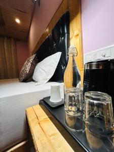 a tray with a bottle and glasses on a bed at Burwa Breeze By Winsum Stays in Palchān