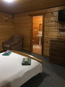 a bedroom with a bed and a chair and a bathroom at Trembita in Yablunytsya