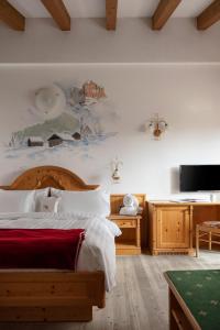 a bedroom with a bed with a painting on the wall at Hotel Gianna in Madonna di Campiglio