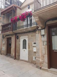 un edificio con una puerta blanca y un balcón con flores en CASA BOURELA, en Cangas de Morrazo