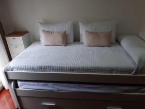 Una cama con dos almohadas encima. en CASA BOURELA, en Cangas de Morrazo