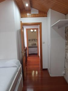 Habitación con dormitorio con cama y pasillo. en CASA BOURELA, en Cangas de Morrazo