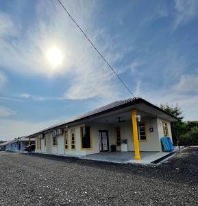 ein kleines gelbes Gebäude mit einem Dach in der Unterkunft Homestay ShimahJay Umbai Melaka in Malakka
