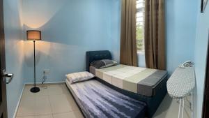 Dormitorio pequeño con cama y lámpara en Homestay ShimahJay Umbai Melaka, en Melaka
