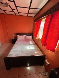 Cama en habitación con cortinas rojas en STONE CASTLE HOTEL, en Freetown