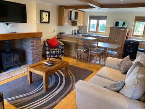 un salon avec un canapé et une table dans l'établissement Red House Farm Cottages, à Beverley 7 autres photos