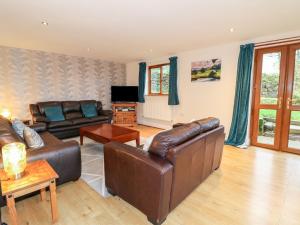 a living room with leather couches and a television at Sunset View in Matlock