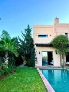 a house with a swimming pool in front of a house at Villa Marrakech piscine privée vue sur Golf&Atlas in Marrakesh