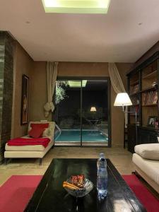 a living room with a couch and a table at Villa Marrakech piscine privée vue sur Golf&Atlas in Marrakech